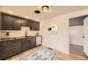 Modern kitchen with dark cabinetry, stainless steel appliances, and tile backsplash at 4035 S Hazel Ct, Englewood, CO 80110