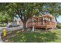 Exterior view of home featuring a two-car garage and a cozy wooden deck with stairs at 4883 W 68Th Ave # 3, Westminster, CO 80030