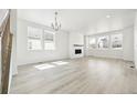 Bright and airy living room featuring large windows, hardwood floors, and a cozy fireplace at 16618 W 92Nd Pl, Arvada, CO 80007