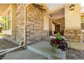 Inviting front porch showcasing stone accents and a glimpse into the home's entrance at 27565 E Nova Pl, Aurora, CO 80016