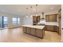 Modern kitchen with stainless steel appliances, a large island, and pendant lighting at 231 Leafy Aster Ln, Castle Rock, CO 80104