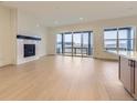 Bright living room with a fireplace, wooden floors, and a sliding glass door leading to a balcony at 231 Leafy Aster Ln, Castle Rock, CO 80104