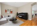 Bright living room featuring hardwood floors, contemporary decor, and an elegant black piano at 6520 S Newcastle Way, Aurora, CO 80016