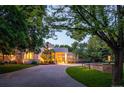 Modern home with a long driveway, lush landscaping, and warm lighting at 52 Sedgwick Dr, Cherry Hills Village, CO 80113