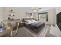 Inviting bedroom with a tufted headboard bed, desk, and soft natural light at 16563 E Kansas Pl, Aurora, CO 80017