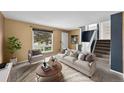 Bright living room with neutral walls, large window, comfortable seating and staircase at 16563 E Kansas Pl, Aurora, CO 80017