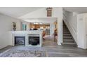 Open-concept living space with a fireplace, staircase and views of the adjacent kitchen area at 611 Branding Iron Ln, Castle Rock, CO 80104