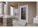 Inviting covered porch with seating area, perfect for relaxing and enjoying the outdoors at 9864 S Garland Ct, Littleton, CO 80127