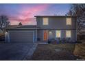 Charming two-story home featuring an attached garage, a well-manicured front yard and a beautiful sunset sky at 114 Walnut Dr, Frederick, CO 80530