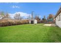 Spacious backyard featuring a well-maintained lawn, storage shed, and a privacy fence at 1932 S Michigan Way, Denver, CO 80219