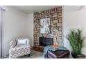 Cozy seating area featuring a stone fireplace and plush chair at 3916 S Telluride Ct, Aurora, CO 80013