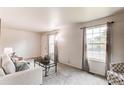 Bright living room with neutral colors, large windows, and a view to the neighborhood at 3916 S Telluride Ct, Aurora, CO 80013
