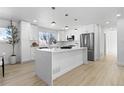 Bright kitchen featuring white cabinets, an island, and stainless steel appliances at 9163 W 75Th Cir, Arvada, CO 80005