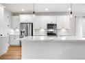 Spacious kitchen featuring a large island with white countertops and shaker style cabinets with stainless steel appliances at 8028 Williams Fork Ave, Littleton, CO 80125