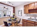 Cozy dining area with a glass table, black chairs and updated kitchen nearby at 745 S Alton Way # 9B, Denver, CO 80247