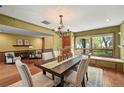 Elegant dining room with hardwood floors, chandelier, and natural light from large window at 11510 Lewistown St, Commerce City, CO 80022