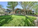 Beautiful green lawn leading up to the home with a covered porch and stone accents at 11510 Lewistown St, Commerce City, CO 80022