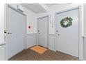 Hallway with three doors and neutral-colored decor in a condo complex at 1265 Race St # 203, Denver, CO 80206