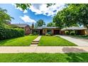 Attractive single-story home with a lush green lawn and beautiful curb appeal at 1635 Poplar St, Denver, CO 80220