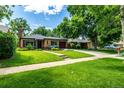 Inviting home with a well-maintained lawn, mature trees, and a private driveway at 1635 Poplar St, Denver, CO 80220