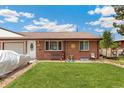 Inviting duplex with a well-kept lawn, brick exterior, and charming front yard decor at 5645 W 5Th Ave # 5645 & 5655, Lakewood, CO 80226