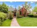 Beautiful brick house with a turret entrance, arched windows, and a lush green front lawn at 1226 Dexter St, Denver, CO 80220