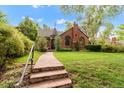 Charming home featuring a stone walkway leading to a brick facade and well-manicured lawn at 1226 Dexter St, Denver, CO 80220