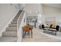 Bright living room with open floor plan, stairs, and a view into the kitchen area at 5950 Gunbarrel Ave # F, Boulder, CO 80301