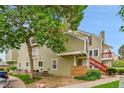 Side view of a townhouse with a large tree, showing a green exterior and brick accents at 922 S Dearborn Way # 8, Aurora, CO 80012