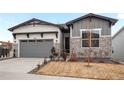 Beautifully designed home with stone accents, two-car garage, and drought resistant landscaping at 5681 Water Avens Dr, Castle Rock, CO 80104