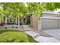 Inviting front entrance with brick accents, well-maintained landscaping, and a cozy porch seating area at 5686 Brook Hollow Dr, Broomfield, CO 80020