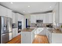 Bright kitchen featuring white cabinetry, stainless steel appliances, granite countertops, and hardwood flooring at 5686 Brook Hollow Dr, Broomfield, CO 80020