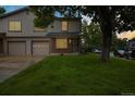 Traditional home featuring a well-manicured lawn and an attached two-car garage in a tranquil neighborhood at 1765 S Kline Way, Lakewood, CO 80232