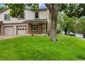 Traditional home featuring a well-manicured lawn and an attached two-car garage in a tranquil neighborhood at 1765 S Kline Way, Lakewood, CO 80232