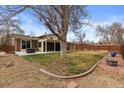 Large backyard featuring mature tree, open lawn space, and patio area for outdoor enjoyment at 2894 S Jay St, Denver, CO 80227