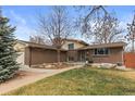 Charming brick home with a well-maintained lawn, mature trees, and inviting walkway at 2894 S Jay St, Denver, CO 80227
