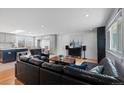 Open living room showcases hardwood floors, shiplap accent wall, and seamless kitchen access at 2894 S Jay St, Denver, CO 80227