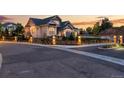 Luxury home with a gated entry and beautiful landscaping at dusk at 6561 S Harlan Ct, Littleton, CO 80123