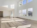 Bright living room featuring soaring ceilings, large windows, and beautiful hardwood floors at 39886 Floyd St, Elizabeth, CO 80107