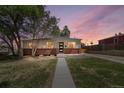 Charming single-story home with brick accents and a modern front door at dusk at 9220 Yucca Way, Thornton, CO 80229
