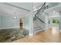Bright entryway showcases a beautiful staircase with iron railings and a blend of slate and hardwood flooring at 7837 Aravon Ct, Lone Tree, CO 80124