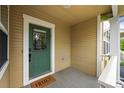 Charming front porch featuring a bright green door and welcoming 'Hello' doormat at 3712 Wolff St, Denver, CO 80212