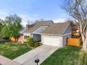 Attractive gray home showcasing well-maintained landscaping, a spacious driveway, and a two-car garage at 3706 E Easter Dr, Centennial, CO 80122
