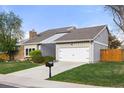 Gray home with a lush green lawn, a convenient driveway, and an attached two-car garage at 3706 E Easter Dr, Centennial, CO 80122