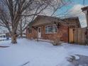 Charming single-story brick home with well maintained exterior and snow covered front yard at 1466 Elmwood Ln, Denver, CO 80221