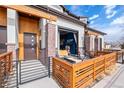 Beautiful exterior with a private front patio, brick accents, and a garage door window at 10105 Morrison Rd, Lakewood, CO 80227