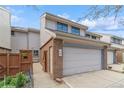 Townhome showcasing a two-car garage, brick accents, and private side entrance at 155 Xenon St # 33, Denver, CO 80228