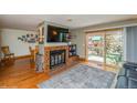 Cozy living room with a brick fireplace, hardwood floors, and sliding glass doors to patio at 155 Xenon St # 33, Denver, CO 80228