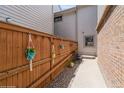 View of a well-maintained side yard with a wooden fence and decorative hanging plants at 155 Xenon St # 33, Denver, CO 80228