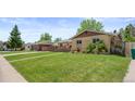Well-maintained ranch-style home with a green lawn, tidy landscaping, and inviting curb appeal at 1195 S Kendall St, Lakewood, CO 80232